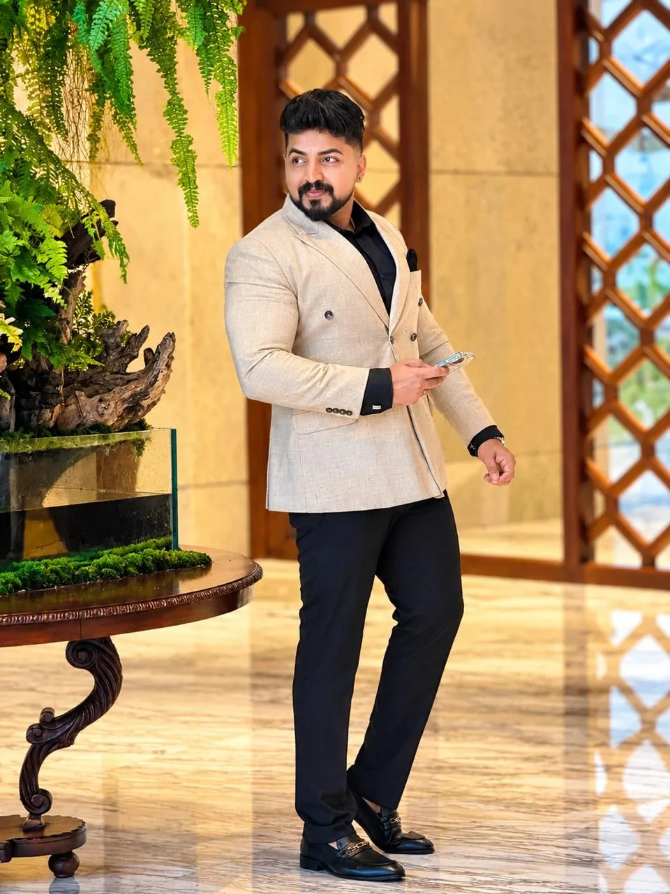 Man wearing a refined beige tailored jacket with black shirt